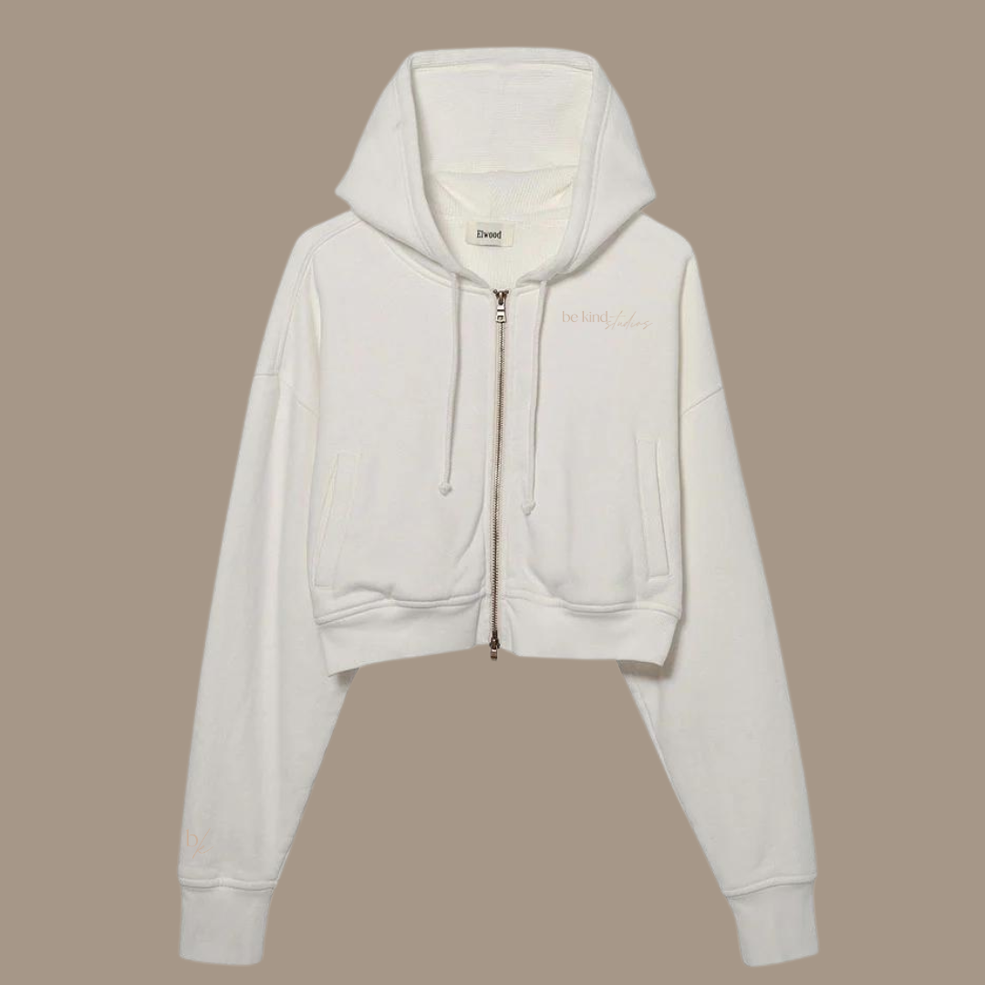 Crop zip hoodie with the words "be kind studios" embroidered on the front.