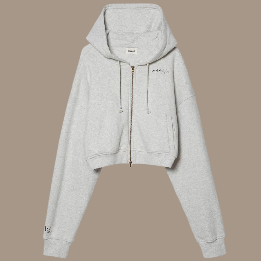 Crop zip hoodie with the words "be kind studios" embroidered on the front.