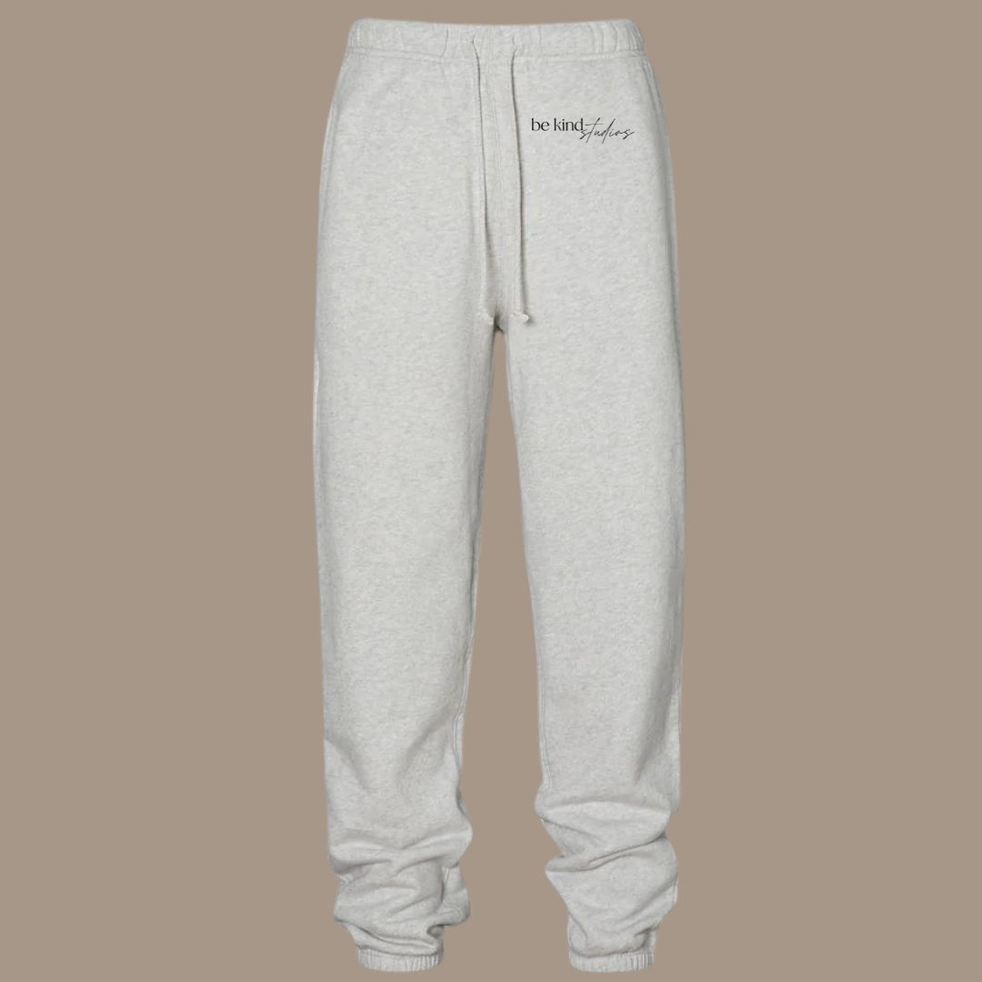 Scrunch leg sweat pants with the words "be kind studios" embroidered on the front.