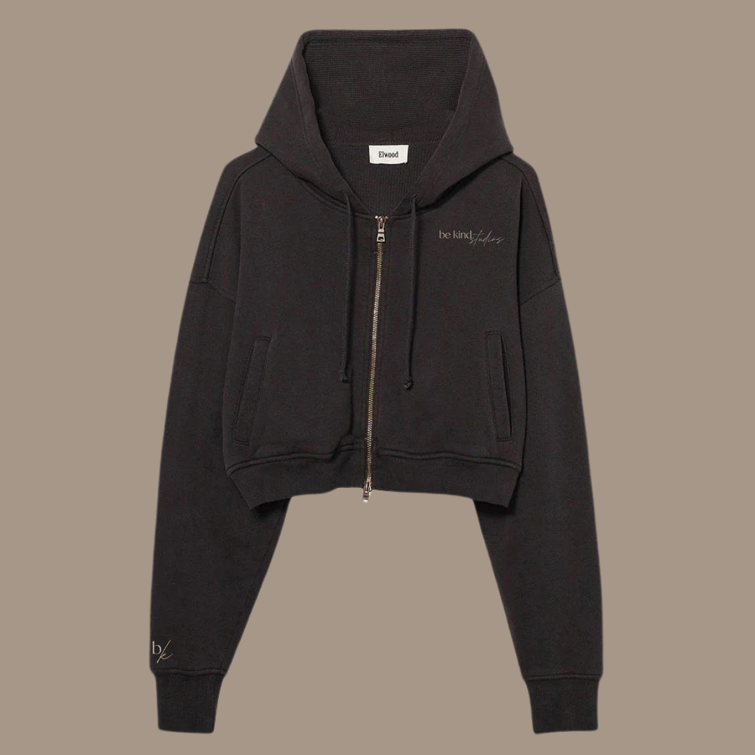 Crop zip hoodie with the words "be kind studios" embroidered on the front.